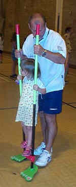 Dad helps his daughter on the stilts