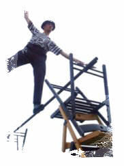 Another Weatherman travels carefully across a pole balanced between chairs.