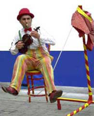 Francis Maxey playing music whilst sitting on a chair on a slack rope!